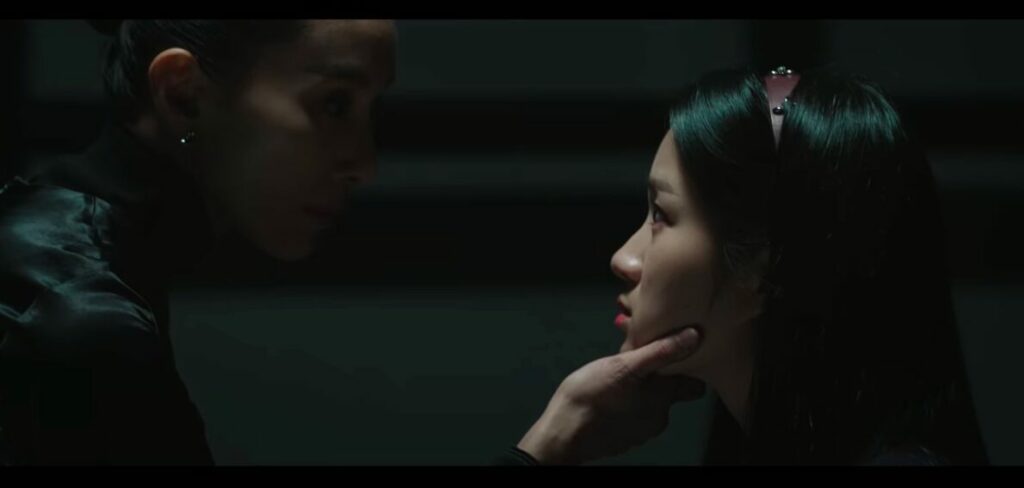 Elite tutot Kim Joo-young from Sky Castle grabs the face of student, Kang Ye-seo in a dark room. It's a symbol of manipulation and intimidation