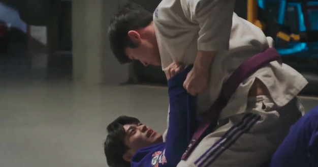 Our two leads grapple with each other in martial arts training