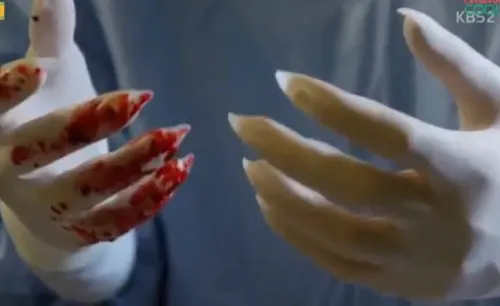 A close up shot of vampire claws in surgical gloves covered in blood