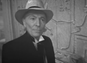 The Doctor in Egypt with a frieze behind him with hieroglyphics.