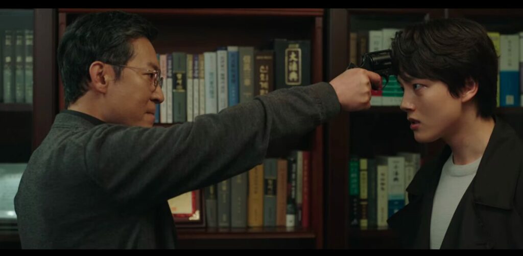 Han Ki-hwan with a gun pointed at his son's head and a look of determination on his face