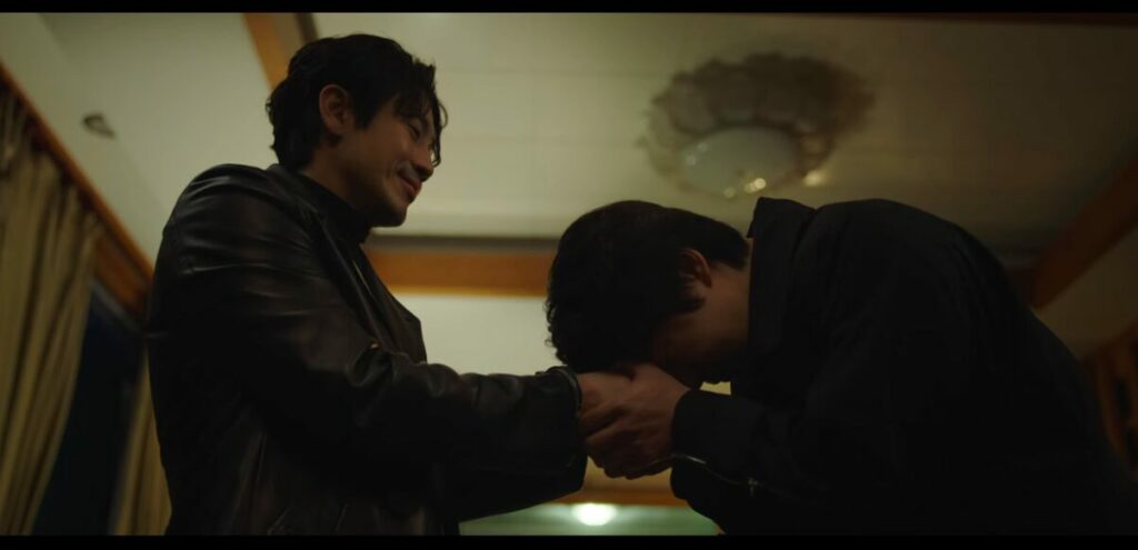Joo-won holds Dong-shik's hands in his and places his head down on them. He's just handcuffed him. Dong-shik looks satisfied