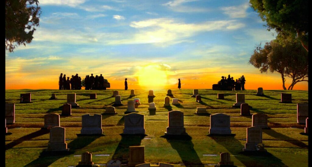 A surreal sunlight over a graveyard causing long shadows from the tombstones. Two children in silhouette on the horizon walk towards each other with the large setting sun between them.