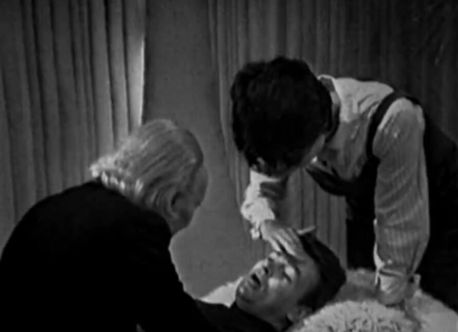 The Doctor and Susan check an unconscious Ian's temperature