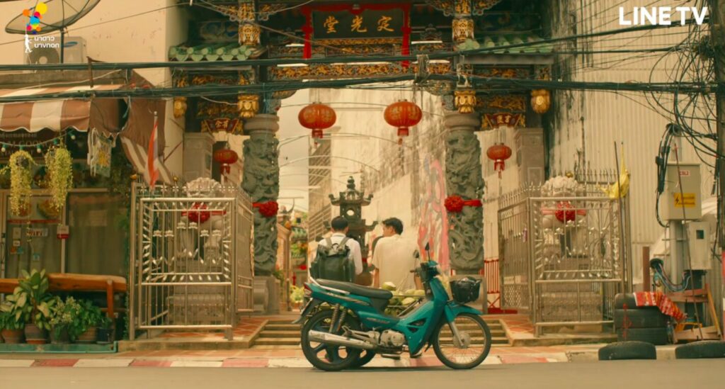 The two boys sit on a parked motorcyle in front of a Buddhit templed housed between business and colonial buildings. It's a study of contrasts between the commercial and spiritual, the old and new, the traditional and the colonial.