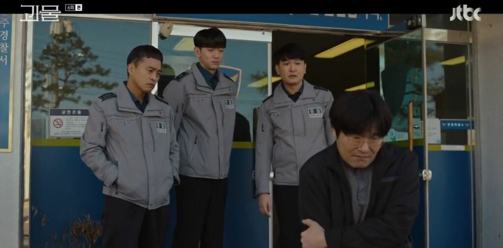 Kang Jin-mook leaves the police station looking pitiable while the police look on concerned