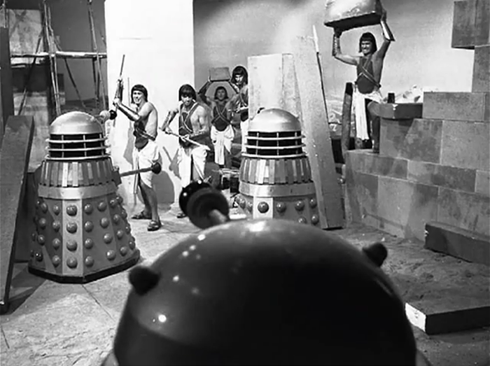 The Daleks fight with Egyptian soldiers armed with rocks and spears