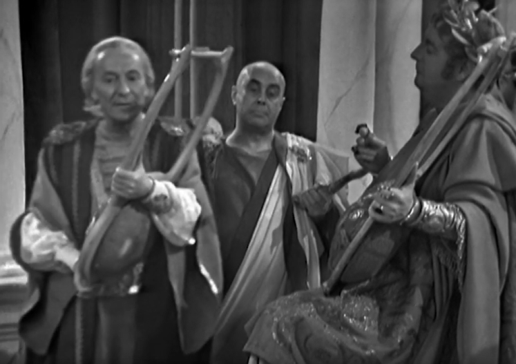 The Doctor, pretending to be Maximum Pettulian, pretends to play the lyre in front of Nero