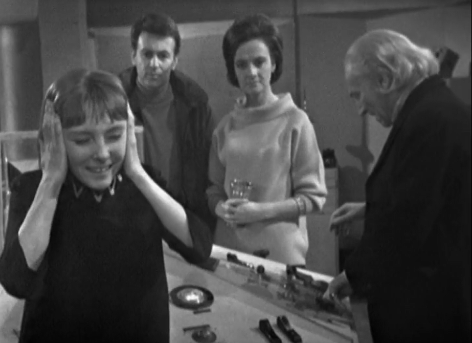 The TARDIS crew are in the console room. The Doctor is fiddling with the controls, Barbara and Ian look concerned and Vicki has her hands over her ears in obvious pain.