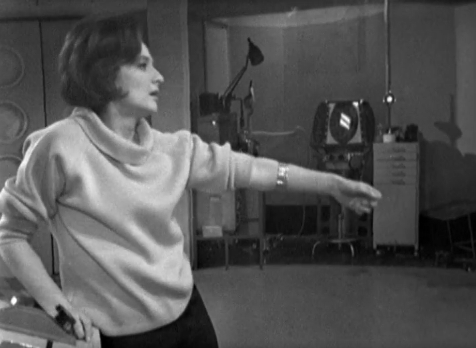 Barbara in a trance like state has her arm outstretched as she's pulled towards the TARDIS door